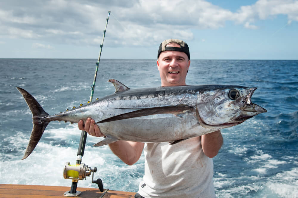 Photo of a Man Holding a Plump Tuna on a Lincoln City Fishing Charter.