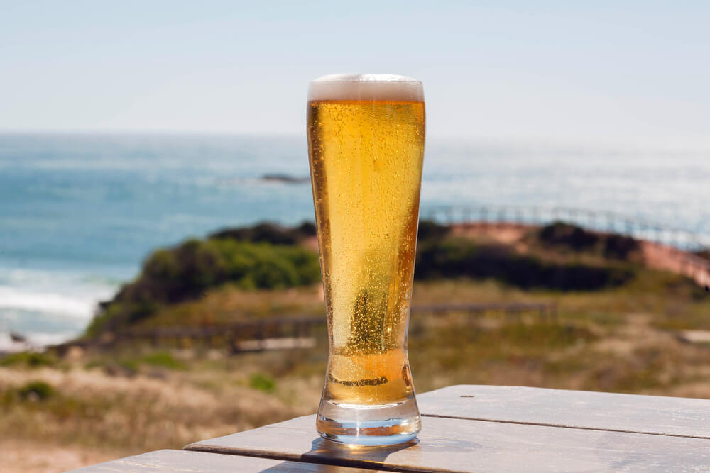 Photo of a Tall Pilsner at an Oregon Coast Brewery with the Sea in the Background.